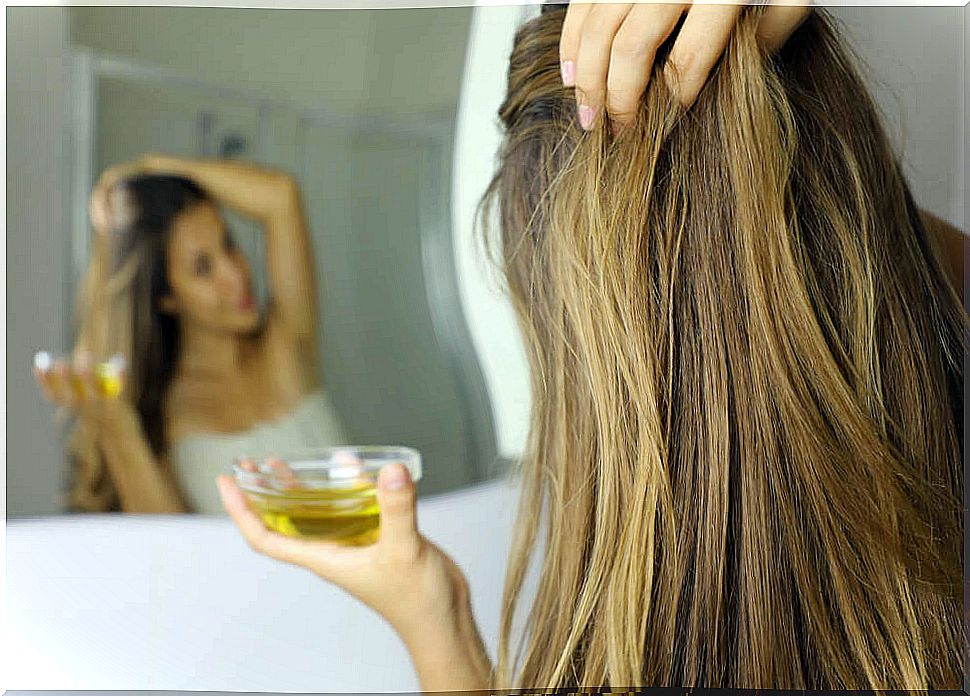 Girl applying oil to her hair.