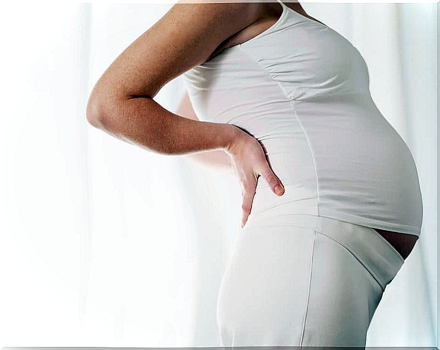 Pregnant woman with hands behind her back