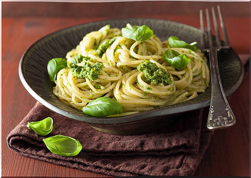 Whole wheat pasta with pesto sauce and cherry tomatoes.