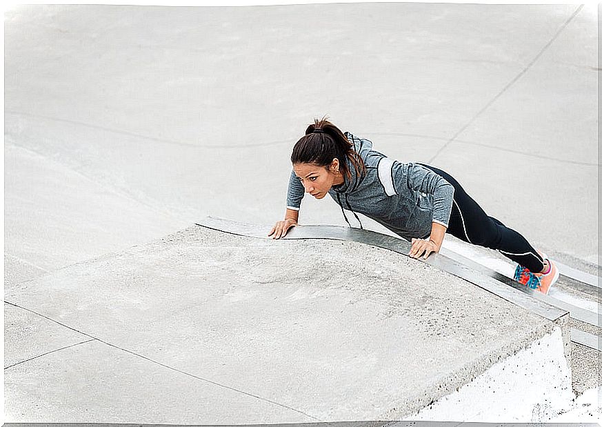 Woman doing push-ups on the stairs.